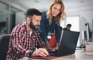 Two coworkers working together on a laptop