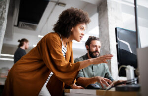 female and male managed IT support employees working on computer