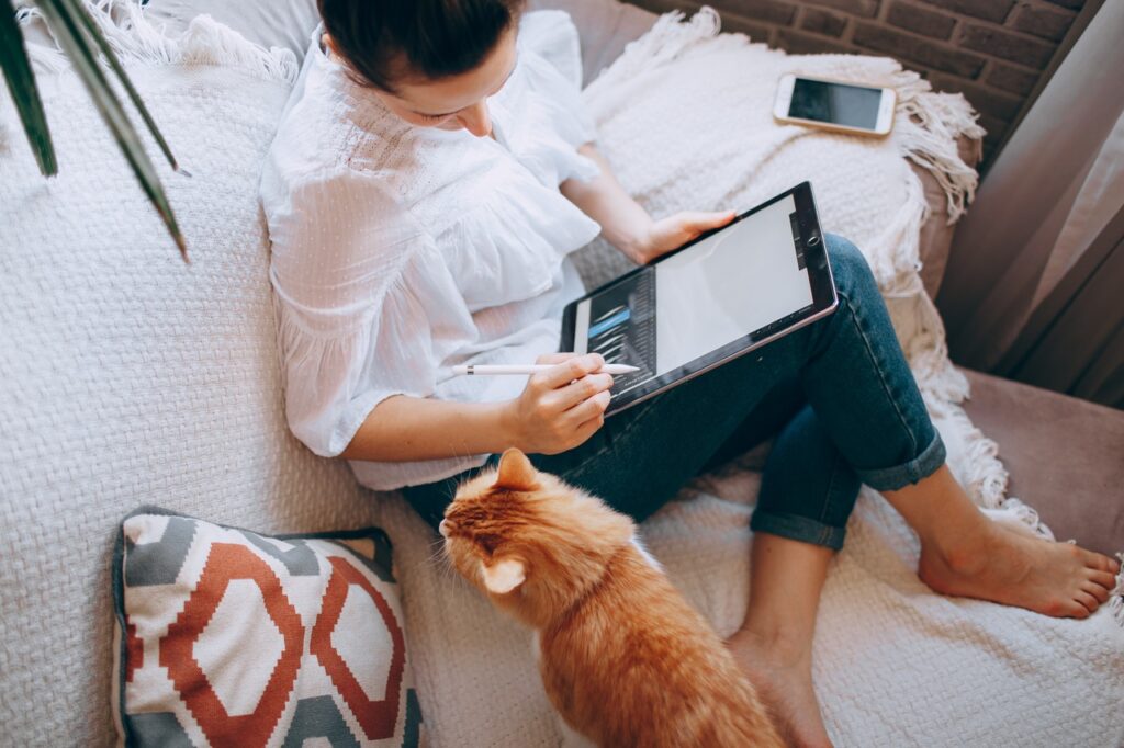 Woman works on a tablet on her couch