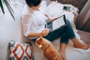 Woman works on a tablet on her couch